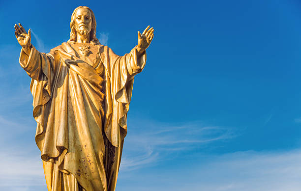 Old Jesus Christ golden statue isolated over blue sky