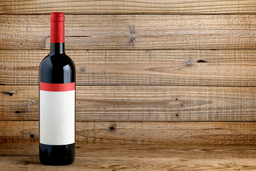 Wine bottle with blank label on wooden background