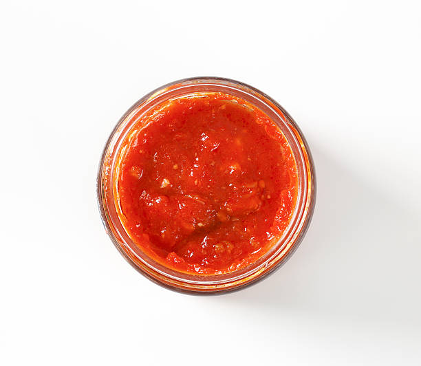 tomato based pesto jar of tomato based pesto sauce on white background savory sauce stock pictures, royalty-free photos & images
