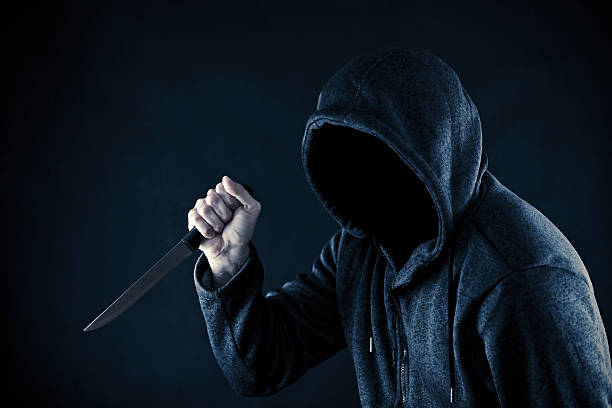 istock Hooded man with knife in the dark 613226764