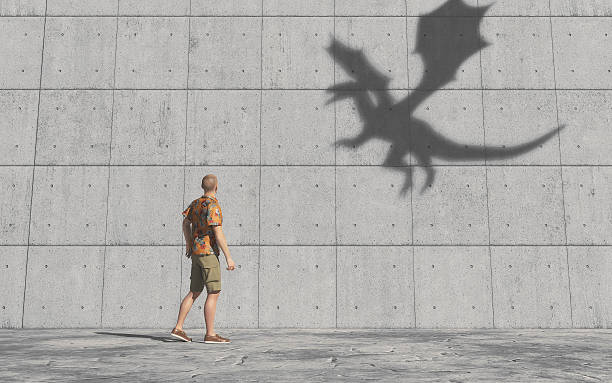 istock Man looks at the shadow of a dragon 613229338