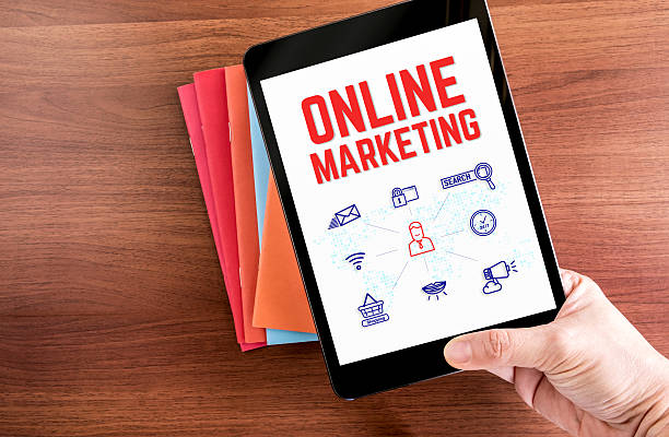 istock hand holding tablet with Online marketing word 613230158