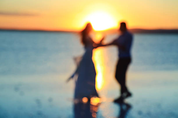 A newlyweds standing on the reflective surface of  Lake Tuz (Aksaray - Ankara), the second largest salted lake of Turkey at sunset on July  08, 2016.