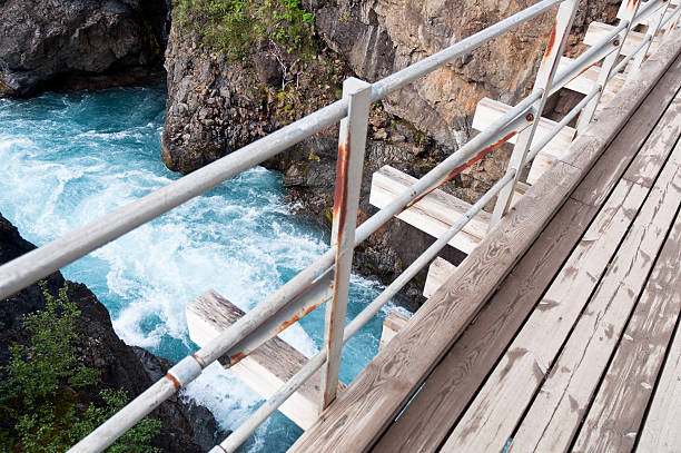istock wooden bridge over wild water canyon 613231304