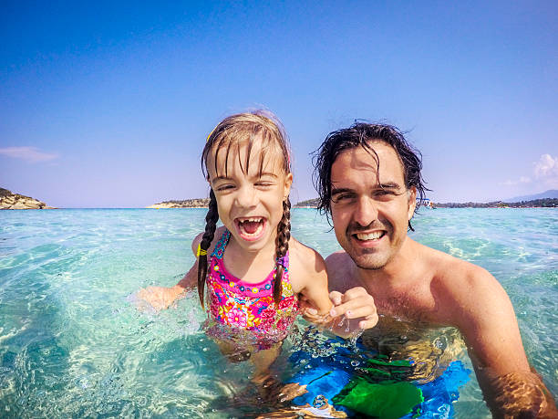istock Father and daughter sea selfie 613231986