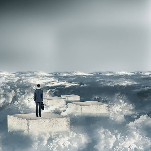 istock Businessman standing on concrete blocks above clouds 613232868