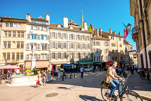 Geneva, Switzerland - June 23, 2016: Bourg-de-four square with people sit in cafes and restaurants. It is the oldest square and the most popular meeting place in Geneva