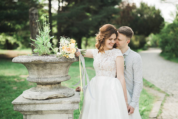 istock Newly married couple running and jumping in park while holding 613233680