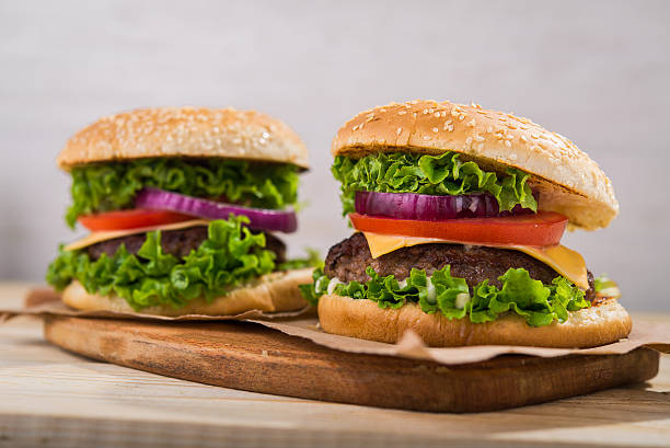 istock burgers on wooden table 613233772