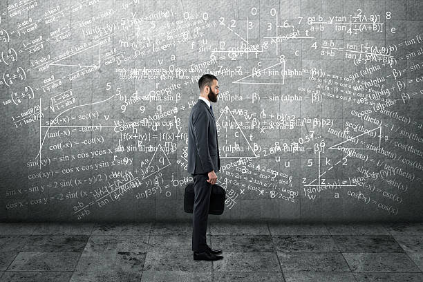 istock Thoughtful businessman standing in front of wall 613235248