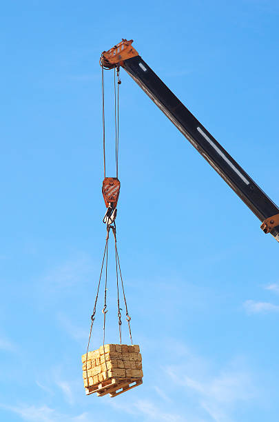 grue et cargaison. - crane hook picking up cargo container photos et images de collection