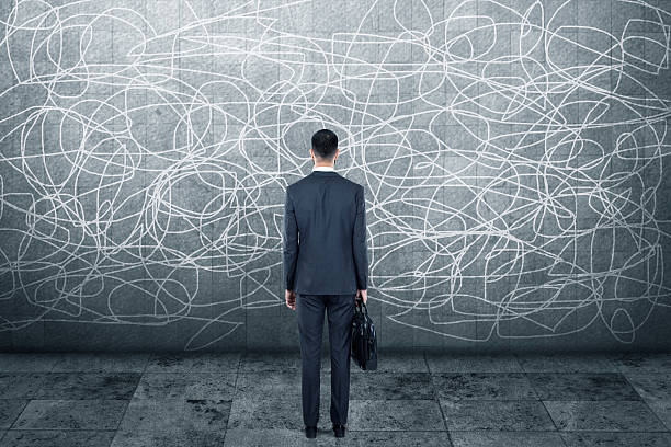 istock Businessman standing in front of wall 613235576