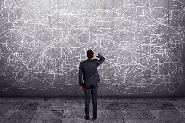 istock Thoughtful businessman standing in front of wall 613236212