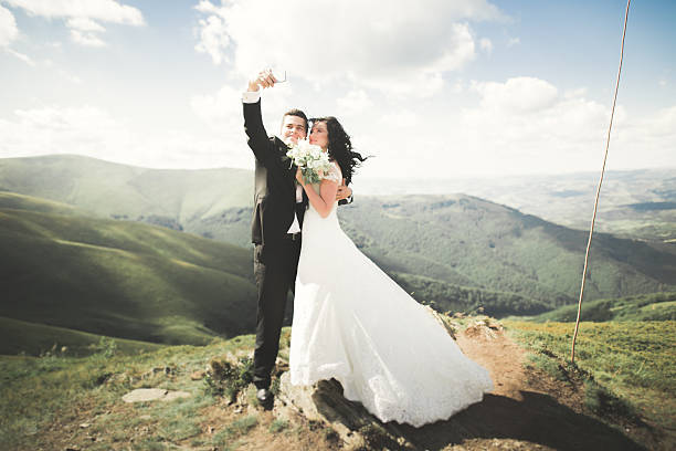 istock Beautiful young wedding couple making selfie on the background of 613236880