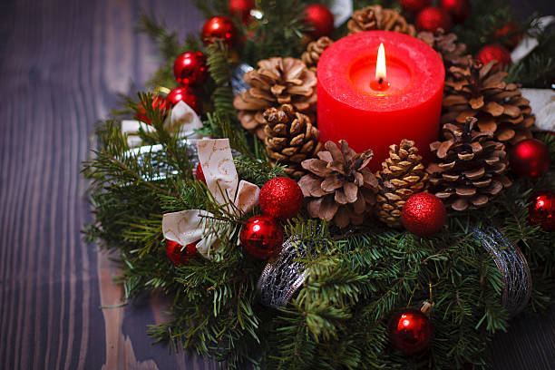 istock Red candle in a wreath of pine branches 613237570