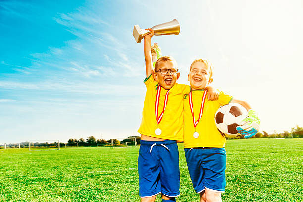 les garçons de soccer célèbrent la victoire avec des médailles et du football - medal soccer success winning photos et images de collection