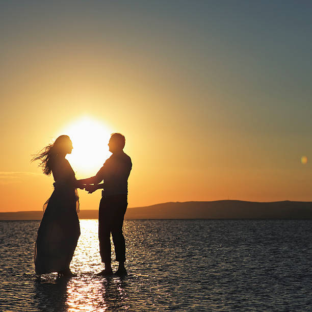 A newlyweds standing on the reflective surface of  Lake Tuz (Aksaray - Ankara), the second largest salted lake of Turkey at sunset on July  08, 2016.