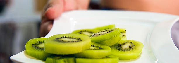 istock Kiwi fruit in white plate on  background 613239052