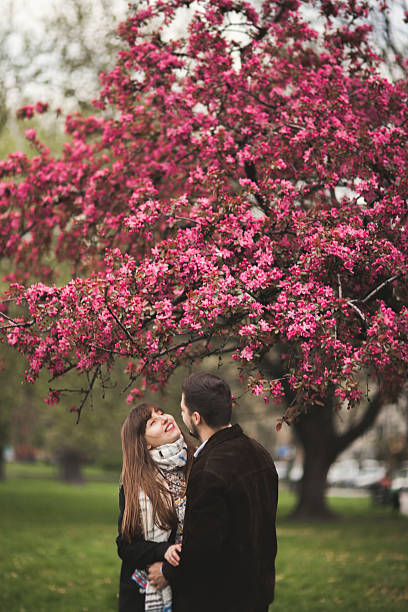 istock Loving couple under a tree with flower in the park 613239154
