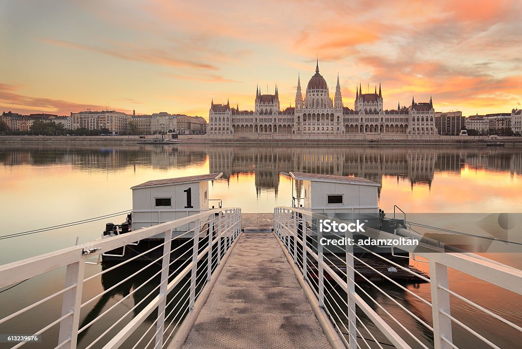 Budapest at sunrise The Hungarian Parliament building with a dock in the foreground in Budapest, Hungary at sunrise. Budapest Stock Photo