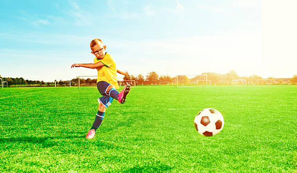 istock Boy plays soccer and kicks a ball on playing field 613240014