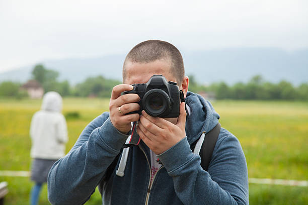 istock Man holding camera and taking photos 613240844
