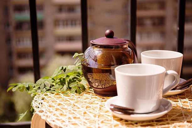 Still life with teapot, cups and cookies on the blurred background