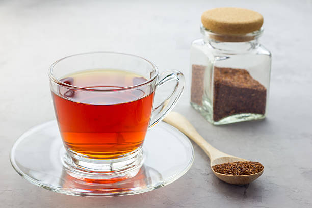 Cup of healthy herbal rooibos red tea in glass cup Cup of healthy herbal rooibos red tea in glass cup and dry tea on background afternoon tea photos stock pictures, royalty-free photos & images