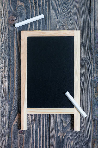 istock Black empty chalkboard for copy space with pieces of chalk 613241860