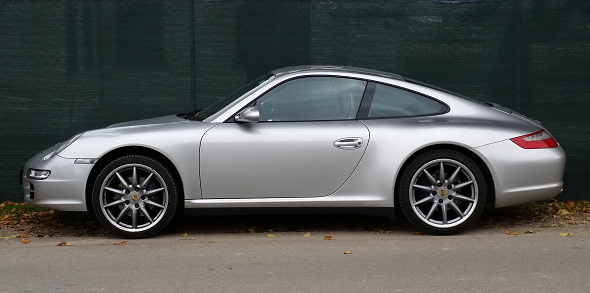 Side view of a Porsche 992 Carrera 4S convertible sports car, parked on a residential London street.