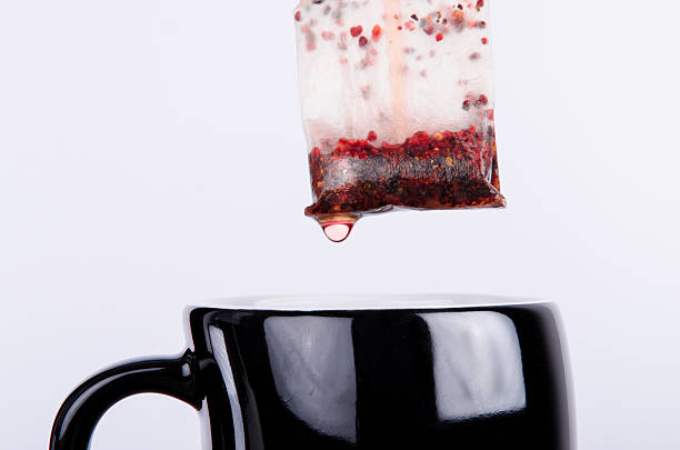 A professional DSLR photo of preparing a black cup of delicious fruity tea. Photo made in a professional photo studio.