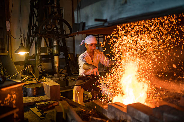 Japanese blacksmith stokes a fire preparing to forge a sword