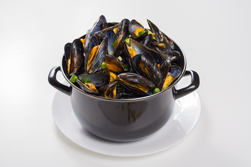North Sea fresh steamed mussels in black pan, tasty seasonal food