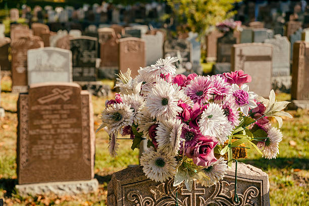 istock Flowers in a cemetery with headstones 613250780