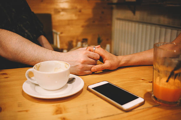 istock Young couple holding hands in a coffee shop 613251974