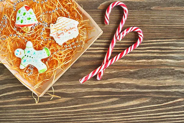 Christmas cookies and candycane on wooden background