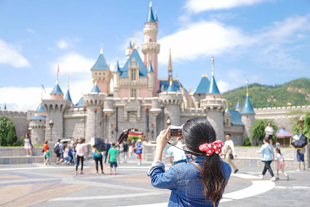 Disneyland Hong Kong, China - Oct 4, 2016: Unidentified Asian teenage girl with a ponytail hairstyle is taking photo of the Fairytales Sleeping Beauty Castle, at Disneyland Hong Kong. Editorial Used Only.  castle photos stock pictures, royalty-free photos & images