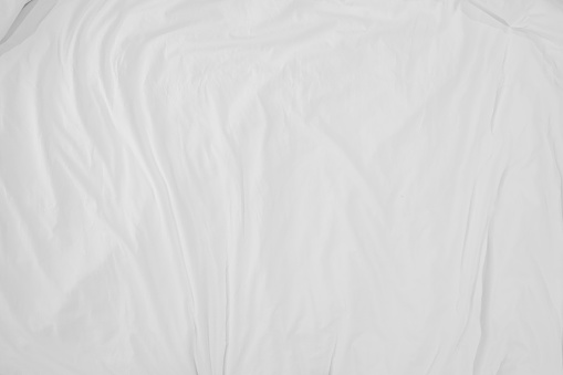Top view of bedding sheets crease,white fabric texture soft focus