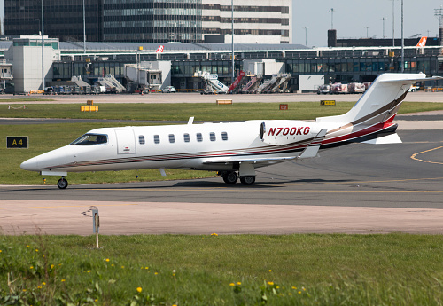 Manchester, United Kingdom - May 8, 2016: Private Bombardier Learjet 45 mid-size business jet aircraft (N700KG) taxiing on Manchester International Airport tarmac.