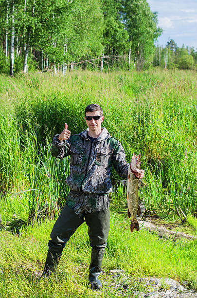 istock Happy Fisherman with his pike 613255592