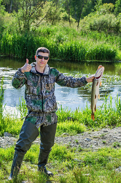 istock Happy Fisherman with his pike 613255822