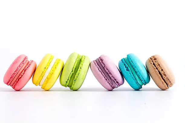 Photo of Collection of brightly colored French macarons on white background