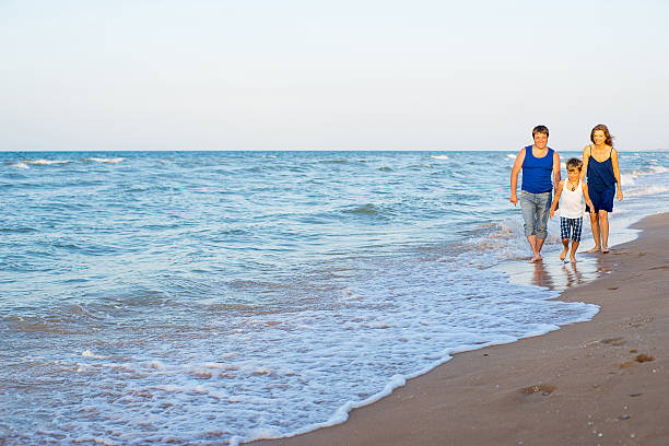istock Family of three having fun at the beach 613302700