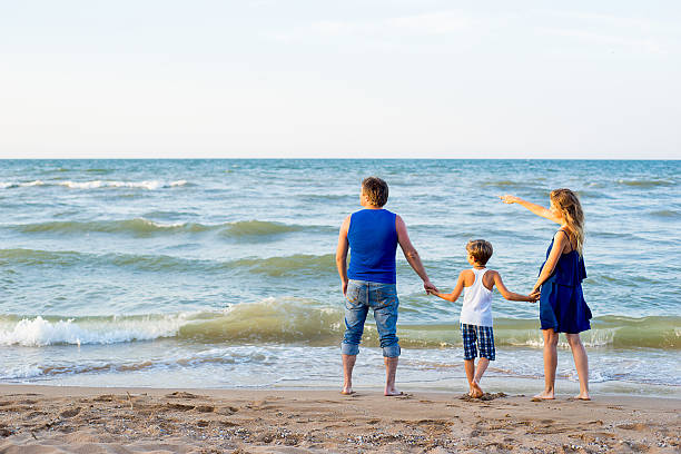 istock Family of three having fun at the beach 613302902