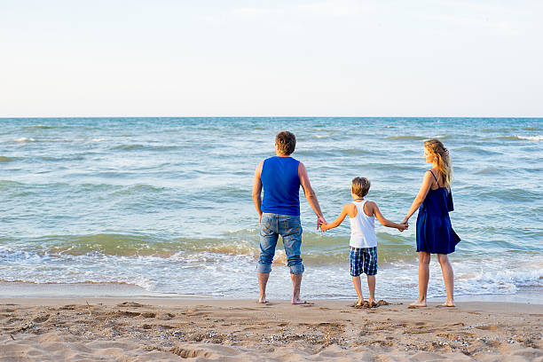 istock Family of three having fun at the beach 613302976