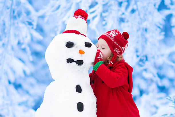 istock Little girl building a snow man 613303096