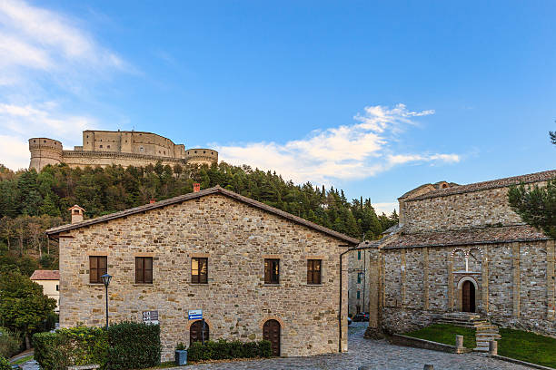San Leo, Italy - October 22, 2014: Old stone buildings in the historic town of San Leo, perched on a rocky outcrop. Upper on the background you can see the fortress, the landmark of the town, visited by thousands of tourists every year. 