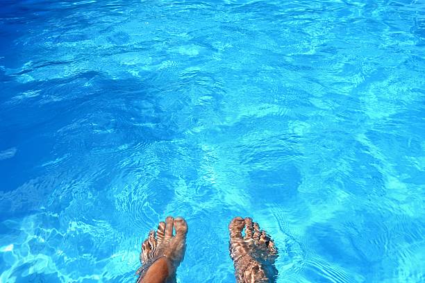 istock Legs in the pool with clean water. Summer background. 613303710