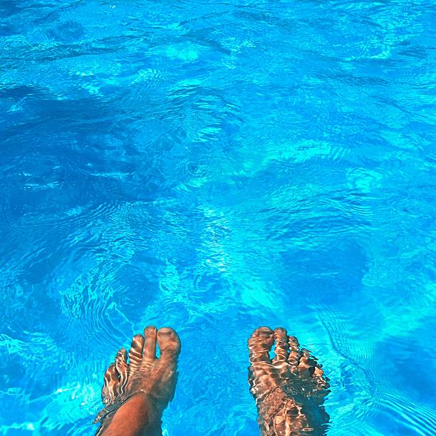 istock Legs in the pool with clean water. Summer background. 613303766