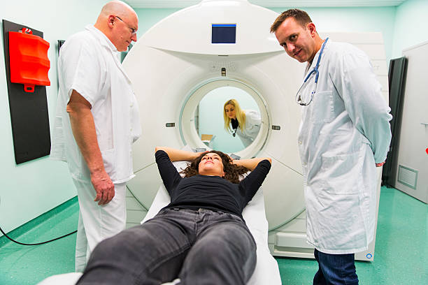 istock Chief radiologist,young doctors and  patient,having PET scan 613307342